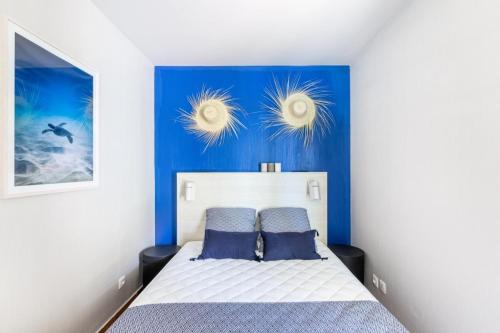 - une chambre avec un mur bleu et un lit dans l'établissement Résidence Les Rivages du Lac - maeva Home - Appartement cosy 3 pièces 6 personnes - Prestige - super Home MAE-0654, à Drammont