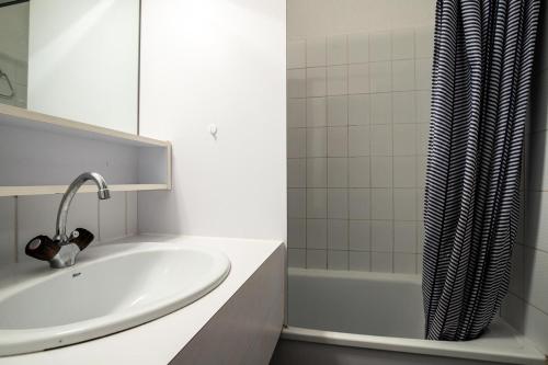 une salle de bain avec un lavabo et un rideau de douche dans l'établissement Résidence Port Bourgenay - maeva Home - Appartement cosy 2 pièces 5 personnes - Sélection - super Home MAE-8934, à Talmont-Saint-Hilaire
