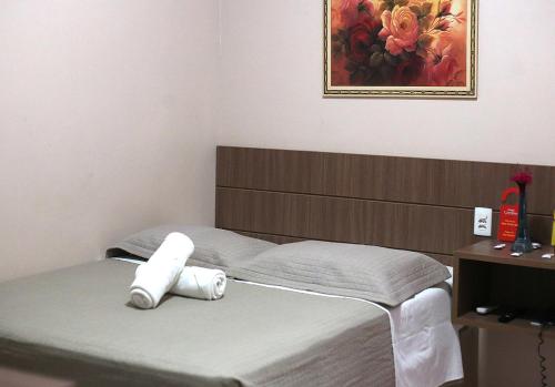 a bed in a room with a picture on the wall at HOTEL CAROLINE in Timon