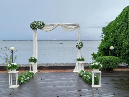 an outdoor altar with a white arch with flowers at Nilakma Lagoon in Negombo