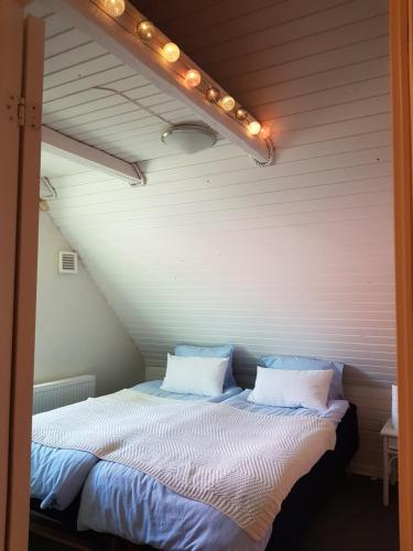 een slaapkamer met een bed met verlichting bij 5min walk to LEGO House - two bedrooms on Loft floor with Balcony * with garden in Billund