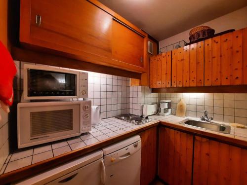 une cuisine avec un micro-ondes et un évier dans l'établissement Résidence Belledonne - Appartement 6 pers ski au pied à la Croisette aux Menuires MAE-4714, aux Menuires
