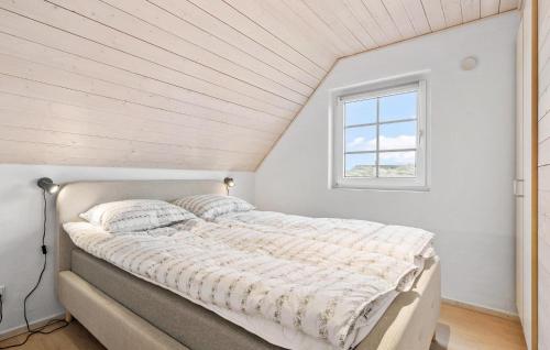 Cama en habitación blanca con ventana en 4 Bedroom Amazing Home In Ringkbing en Nørre Lyngvig