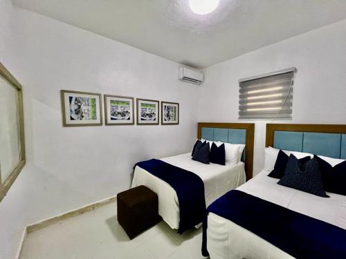 a bedroom with two beds with blue and white sheets at Janer House at San Juan in San Juan
