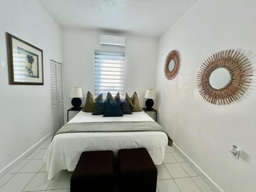 a white bedroom with a large bed and a mirror at Janer House at San Juan in San Juan