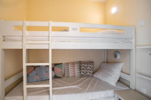 Cette chambre dispose de lits superposés et d'un ours en peluche. dans l'établissement Résidence le Hameau des Issambres - maeva Home - Appartement 3 Pièces 6 Personnes - Sélection MAE-7804, aux Issambres