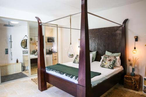 - une chambre avec un lit à baldaquin et une salle de bains dans l'établissement Séjour détente en Provence, à Ventabren