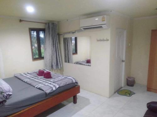 - une chambre dotée d'un lit avec des chaussures rouges dans l'établissement รีสอร์ท สุพรรณ, à Suphanburi