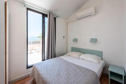 une chambre avec un lit et une grande fenêtre dans l'établissement Résidence Cannes Villa Francia - maeva Home - Appartement 2 pièces 6 personnes - Sélection MAE-2534, à Cannes