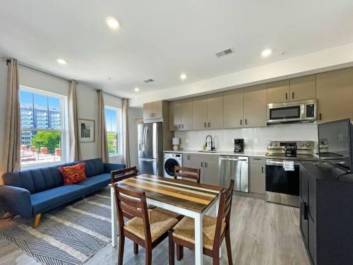 a kitchen and living room with a table and a blue couch at Luxury Penthouse , Private RoofDeck & Amazing View in Washington, D.C.