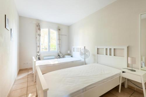 - une chambre blanche avec un lit et un lavabo dans l'établissement Village Pont Royal en Provence - maeva Home - Maison 4 pièces 8 personnes - 694, à Mallemort