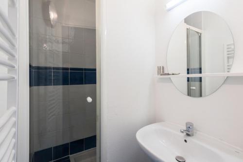 ein weißes Badezimmer mit einem Waschbecken und einem Spiegel in der Unterkunft Village Pont Royal en Provence - maeva Home - Maison 4 pièces 8 personnes - 694 in Mallemort