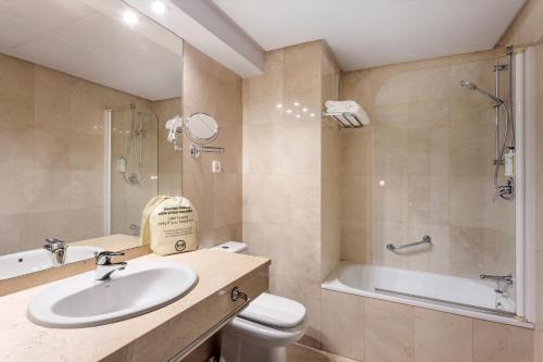 a bathroom with a sink and a toilet and a tub at B&B HOTEL Cartagena Cartagonova in Cartagena