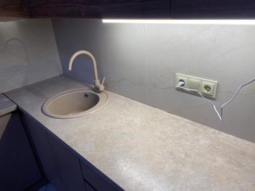 een badkamer met wastafel en stopcontact bij New & Fully Equipped Apartment in Gldani in Tbilisi City
