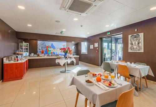 a restaurant with tables and chairs and a counter at B&B HOTEL Colmar Liberté 4 étoiles in Colmar