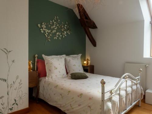 1 dormitorio con 1 cama blanca con flores en la pared en REVES DE BAIE - Accueillant, Paisible, Vue panoramique exceptionnelle, en Tirepied