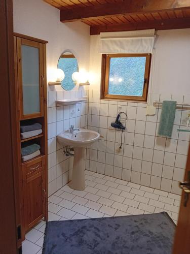 ein Bad mit einem Waschbecken und einem Fenster in der Unterkunft Lüüntjenest in Elsfleth