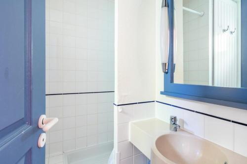 une salle de bain avec un lavabo et un miroir dans l'établissement Les Maisons de Lacanau les Pins - maeva Home - Maison 3 Pièces 8 Personnes - Budget MAE-9364, à Lacanau