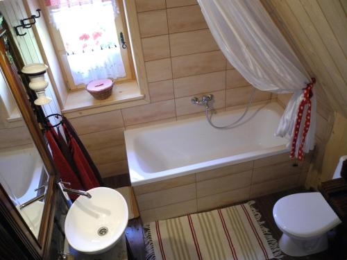 a bathroom with a tub and a toilet and a sink at Zrubový domček u Vincka 2 in Ždiar