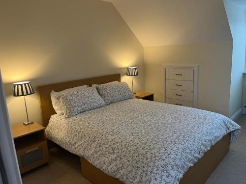 a bedroom with a bed and two lamps on tables at Ardmore Village Family Home in Ardmore