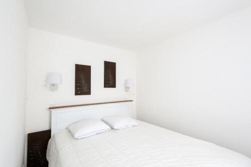 une chambre avec un lit blanc avec deux oreillers dans l'établissement Village Pont Royal en Provence - maeva Home - Appartement 2 Pièces 6 Personnes - Sélection MAE-9534, à Mallemort