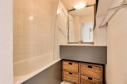 une salle de bain avec un lavabo, une baignoire et un miroir dans l'établissement Résidence Port Bourgenay - maeva Home - Appartement 2 pièces 4 personnes avec vue sur le lac - Prestige - super Home MAE-9654, à Talmont-Saint-Hilaire