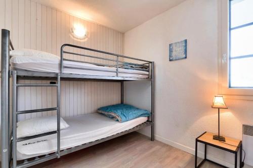 Cette chambre dispose de lits superposés avec deux lits superposés et une lampe. dans l'établissement Résidence Port Bourgenay - maeva Home - Appartement 2 pièces 4 personnes avec vue sur le lac - Prestige - super Home MAE-9654, à Talmont-Saint-Hilaire