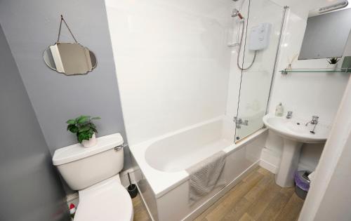 a white bathroom with a toilet and a sink at Argyll Apartments - Drimvargie Terrace, Oban in Oban