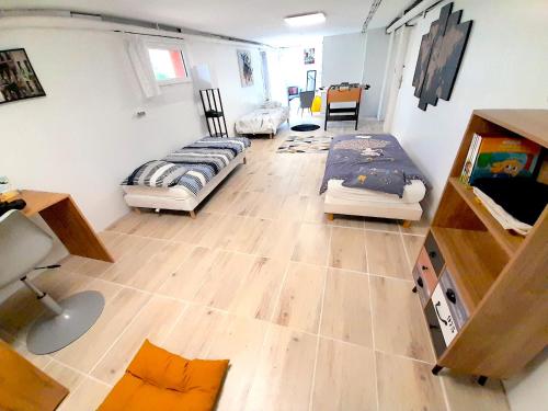 Pokój z 3 łóżkami i drewnianą podłogą w obiekcie À 2mn de la plage, maison avec grand terrain clos w mieście Plérin
