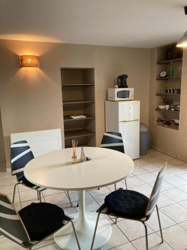 - une table et des chaises dans une pièce avec cuisine dans l'établissement Cholet 500m du cormier 15 min du puy du fou, à Cholet