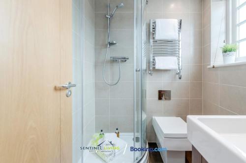 a bathroom with a shower and a toilet and a sink at Windsor, 2 Bedroom Apartment By Sentinel Living Short Lets & Serviced Accommodation Windsor Ascot Maidenhead With Free WiFi in Windsor