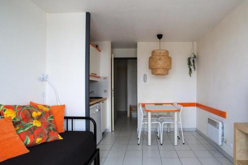 Ce petit appartement comprend une table et une cuisine. dans l'établissement Résidence Quai des Voiliers 2 - maeva Home - Studio 4 Personnes - Confort - vue sur le Port MAE-7094, à Arzon