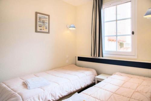 une chambre avec deux lits et une fenêtre dans l'établissement Résidence Port Bourgenay - maeva Home - Appartement 2 pièces 5 personnes - Sélection MAE-9144, à Talmont-Saint-Hilaire