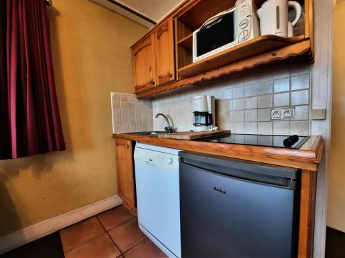 Il comprend une petite cuisine équipée d'un évier et d'un lave-vaisselle. dans l'établissement Résidence Charmette - Appartement 5 personnes ski aux pieds aux Ménuires MAE-4974, aux Menuires