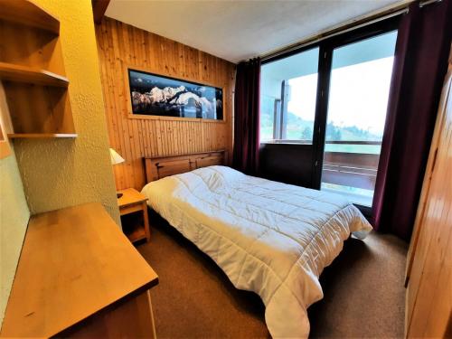 une chambre avec un lit et une grande fenêtre dans l'établissement Résidence Charmette - Appartement 5 personnes ski aux pieds aux Ménuires MAE-4974, aux Menuires