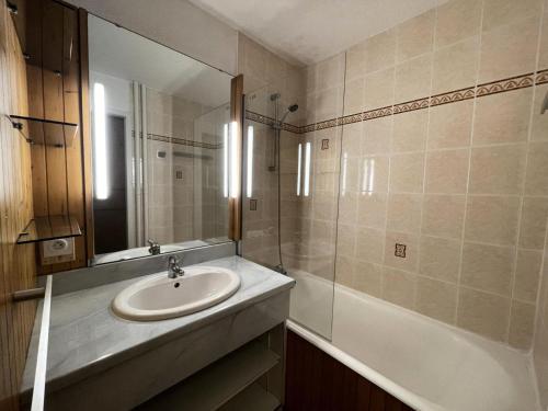 une salle de bain avec un lavabo, un miroir et une baignoire dans l'établissement Résidence Chaviere - Appartement traversant pour 5 personnes MAE-4984, aux Menuires