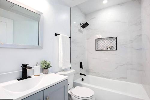 a white bathroom with a toilet and a sink at Amazing Capital Hill APT , Step away Gym, shopping in Washington, D.C.