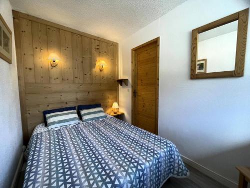 - une chambre avec un lit et un mur en bois dans l'établissement Résidence Beaufortain - Appartement 4 personnes avec vue sur la Croisette MAE-5004, aux Menuires