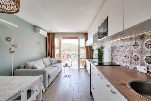 une cuisine et un salon avec un canapé et une table dans l'établissement Résidence le Village de Cap Esterel - maeva Home - Appartement moderne 2 pièces 5 personnes - Prestige - super Home MAE-6974, à Saint-Raphaël