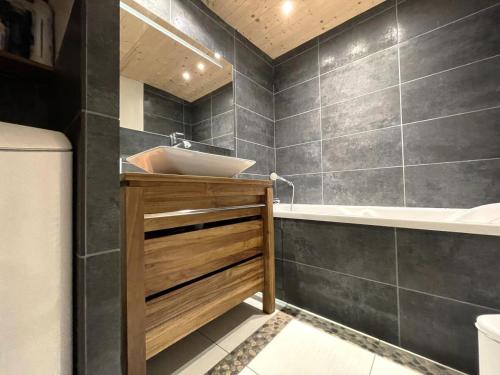 une salle de bain avec un lavabo et une baignoire dans l'établissement Résidence La Croix De Fer - Appartement vouté rénové à St Martin de Belleville MAE-4994, à Saint-Martin-de-Belleville