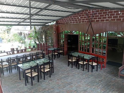 a patio with tables and chairs and a brick wall at Grand Selva Lodge & Tours in Tena