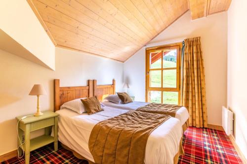 une chambre avec deux lits et une fenêtre dans l'établissement Résidence Les Arcs 1950 Le Village - maeva Home - Appartement 4 pièces 8 personnes - Prestige MAE-9724, à Bourg-Saint-Maurice