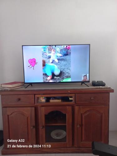 a flat screen tv sitting on top of a wooden entertainment center at Casa Teresa in El Talar de Pacheco