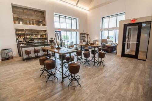 a room with tables and chairs and a bar at Hotel Renovo Des Moines Urbandale,Tapestry Collection Hilton in Urbandale