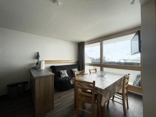 un salon avec une table et un canapé dans l'établissement Résidence Trois Marches - Appartement rénové pour 4 personnes exposé Sud MAE-5034, aux Menuires