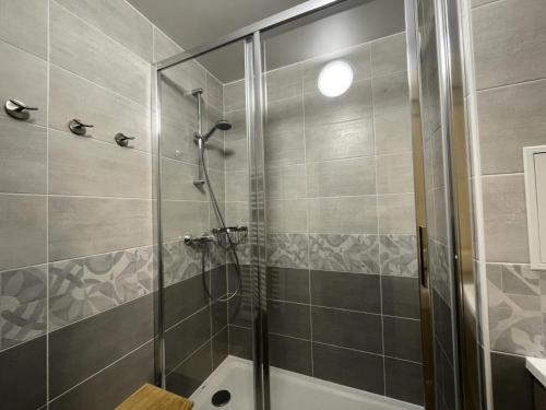 une douche avec une porte vitrée dans une salle de bain dans l'établissement Résidence Trois Marches - Appartement rénové pour 4 personnes exposé Sud MAE-5034, aux Menuires