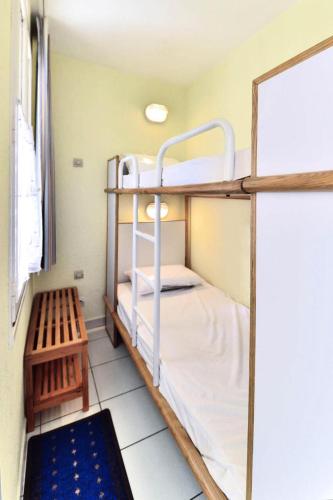 Cette chambre dispose de lits superposés avec 2 lits superposés et un banc. dans l'établissement Résidence Quai des Voiliers 2 - maeva Home - Studio 4 Personnes - Budget - vue sur le Port MAE-4194, à Arzon