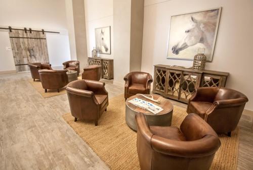 a waiting room with chairs and a horse painting on the wall at Hotel Renovo Des Moines Urbandale,Tapestry Collection Hilton in Urbandale