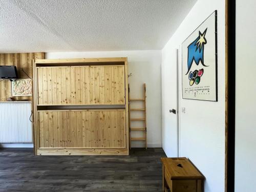 um quarto com uma porta de madeira e uma escadaria em Résidence Lac Du Lou - Studio pour 4 Personnes 074 em Les Menuires