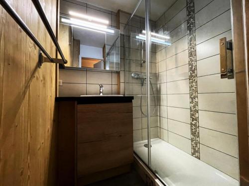 uma casa de banho com um chuveiro, um lavatório e uma banheira em Résidence Lac Du Lou - Studio pour 4 Personnes 074 em Les Menuires